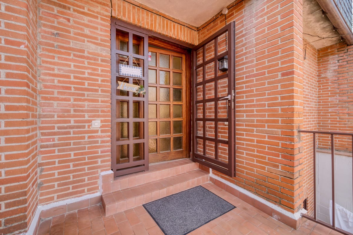 A wooden home entrance set into brickwork