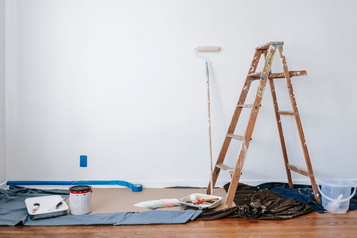 Protective covering laid over a floor beside decorating supplies