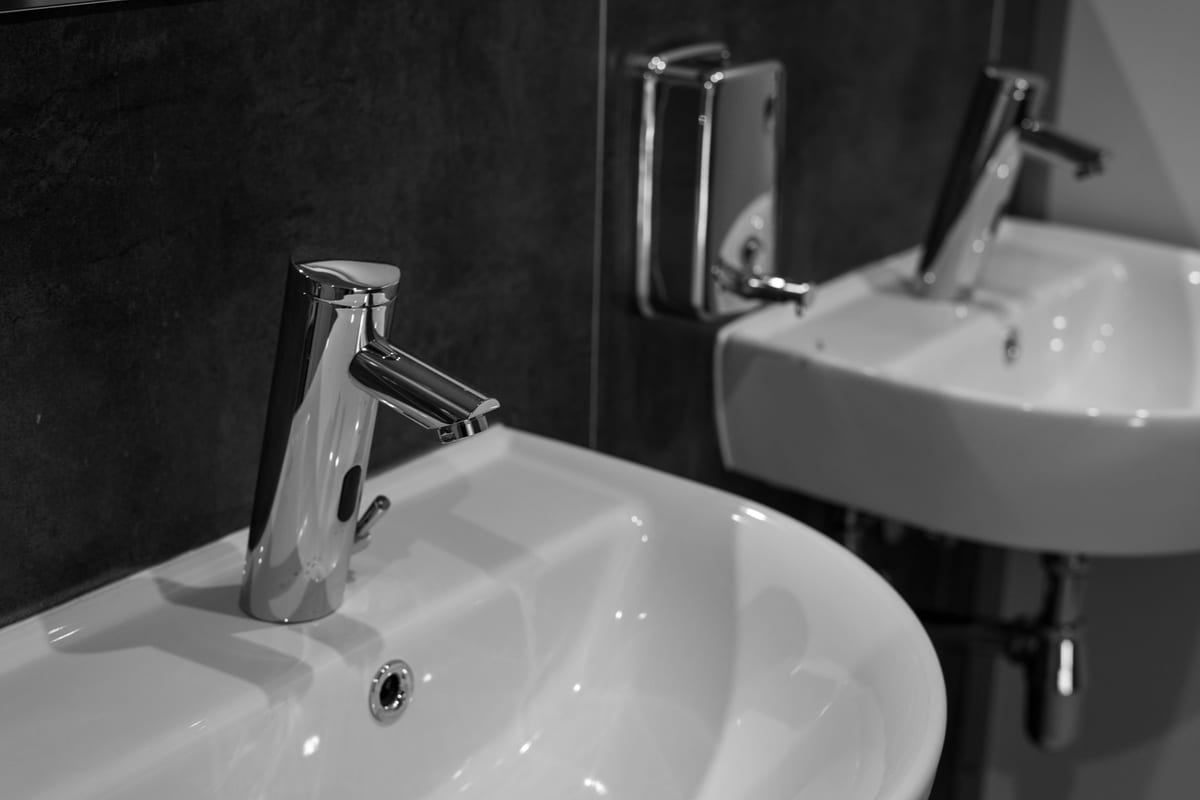 Chrome tap assembly above a white basin
